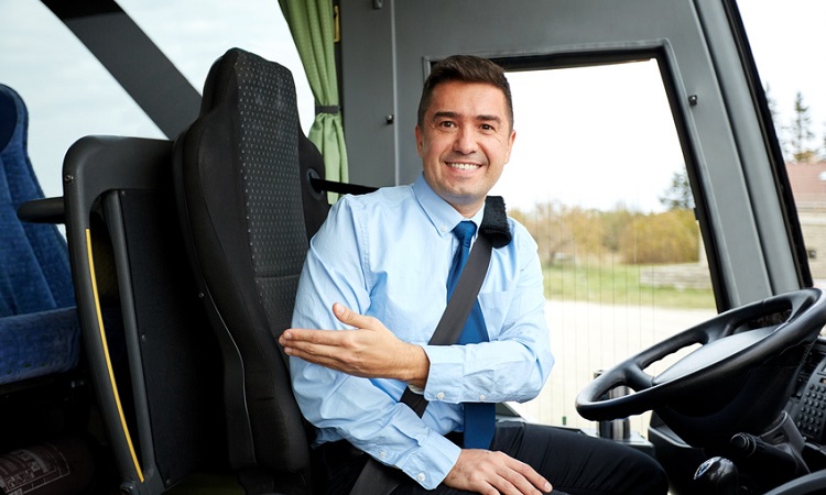 Ein Busfahrer begrüßt seine Fahrgäste. 